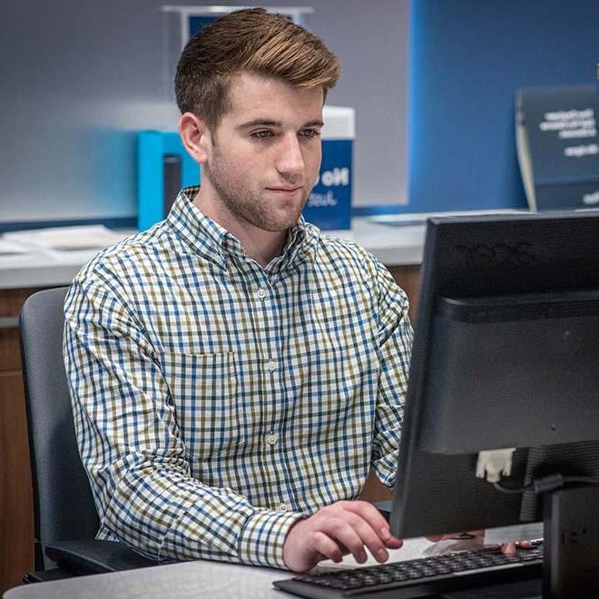College student working at computer as part of internship