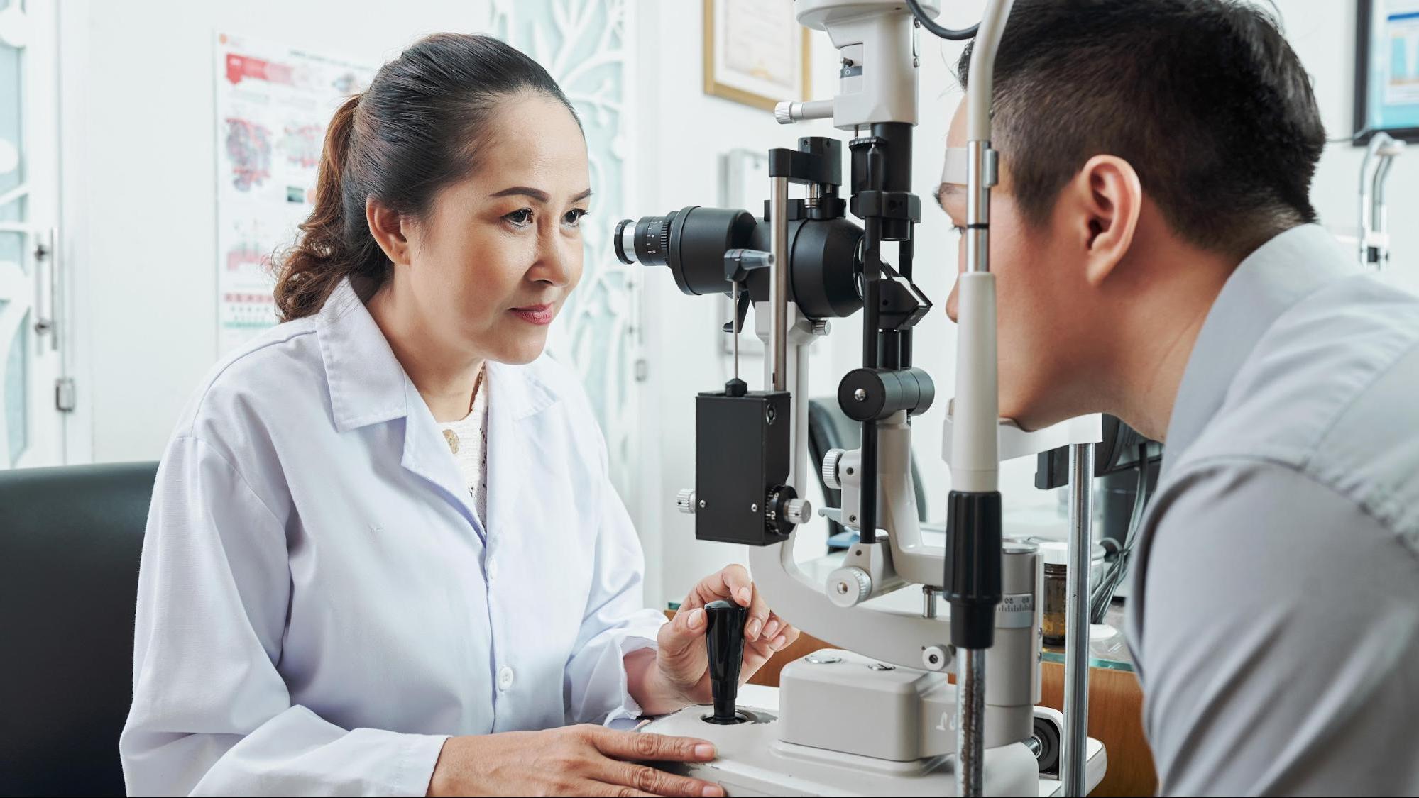 Optometrist giving eye exam to patient